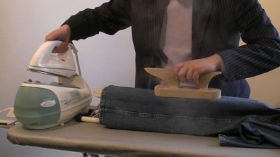 image of a steam iron being used at a sewing class. When you learn to sew you will need to invest in a steam iron as pressing is just as important as actually making the garment. Our easy to follow step by step sewing courses will teach you how to sew and create any garment and accessory of your choice #learntosew #learntotailor #learntailoringonline